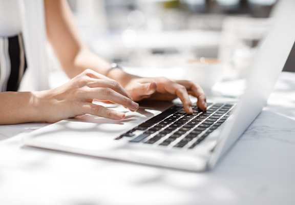 a woman typing on a laptop computer