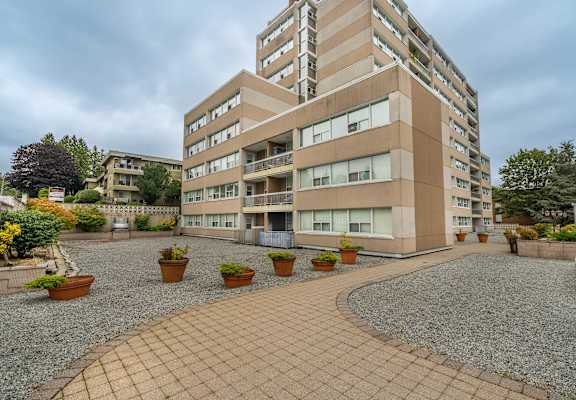 A multi-story building with a courtyard in front.