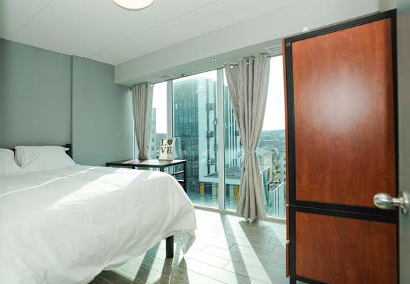 a bedroom with a bed and a door to a balcony