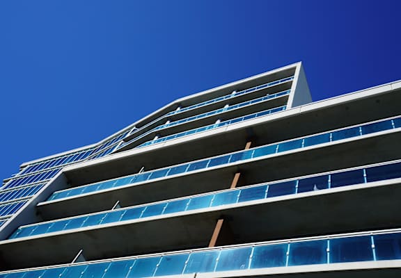 a tall building with blue windows against a blue sky