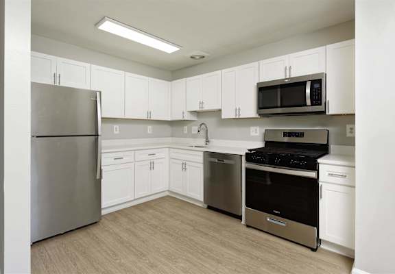 A kitchen with white cabinets and stainless steel appliances.