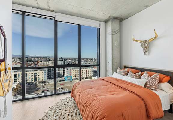 Beautifully decorated bedroom with comfortable bed at Velaris Living Apartments, Denver, CO, 80205