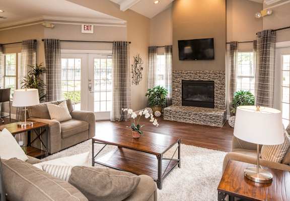 A living room with a fireplace and a flat screen TV mounted above it. at Infinity on Sunnyvale Apartments , Mesquite, 75150