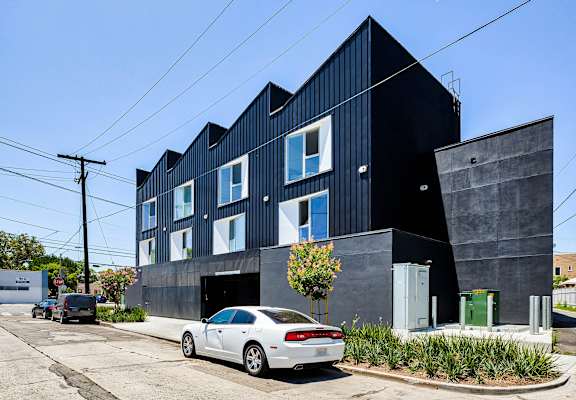 A modern black building with a white car parked in front.at 5263 W Adams, Los Angeles California