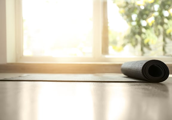 a yoga mat on a wooden floor in front of a window