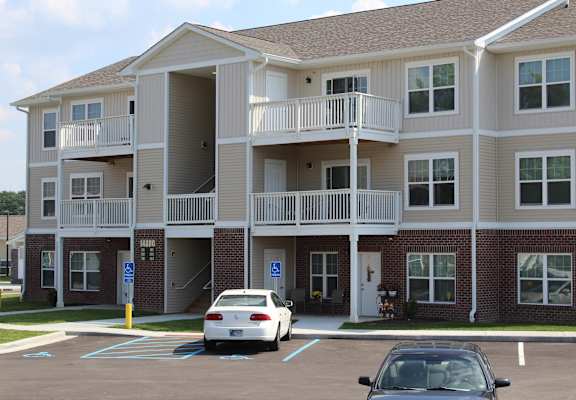 an apartment building with cars parked in front of it at Salem Place Apartments, Daleville, 47334