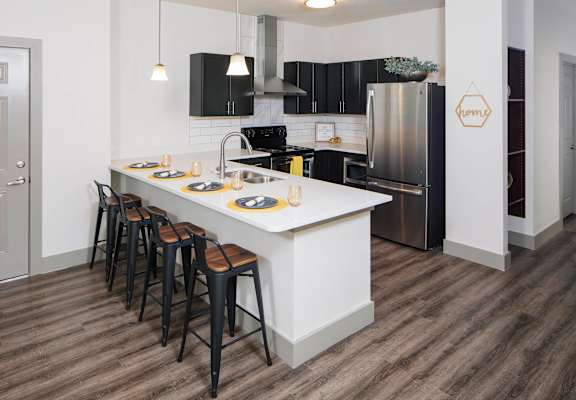 a kitchen with a large island and black appliances at Ritchey Reserve, Fishers, 46038