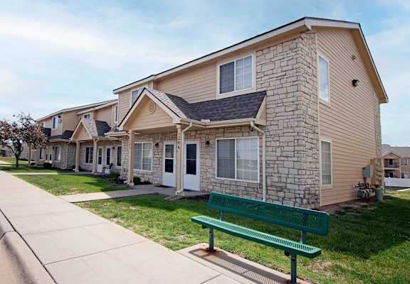 A row of houses with a green bench in front of them.