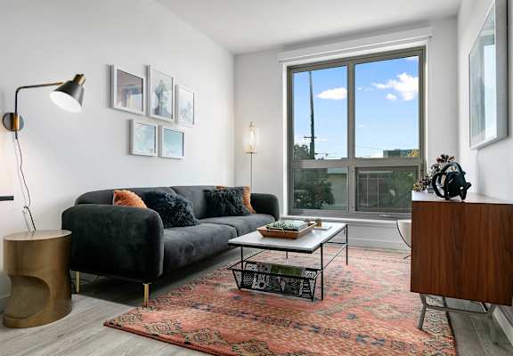 A living room with a black couch and a coffee table.