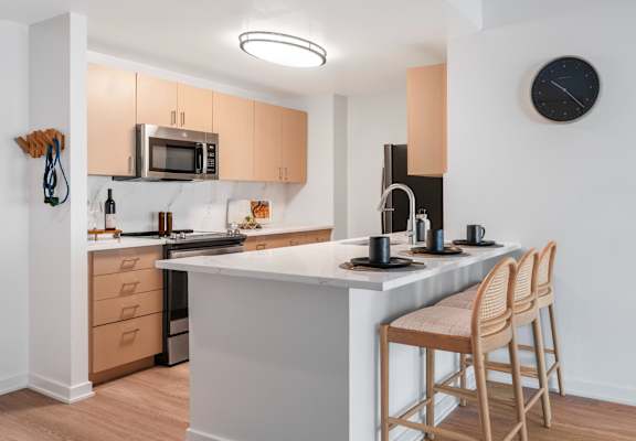 a kitchen with an island with two stools in front of it