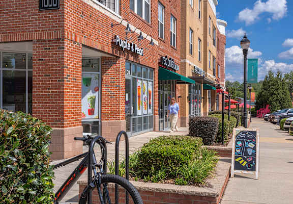 A person is walking outside of a store named Purple & Pearl.