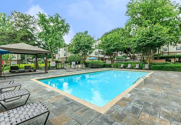 A pool surrounded by trees and a patio area at 400 Winchester Apartments, GA, 30339