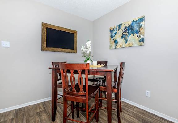 a dining room table with chairs and a painting on the wall at The Davis Apartments, Huntsville, 35816