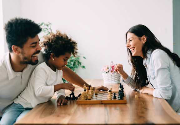 A family playing chess together at a table.