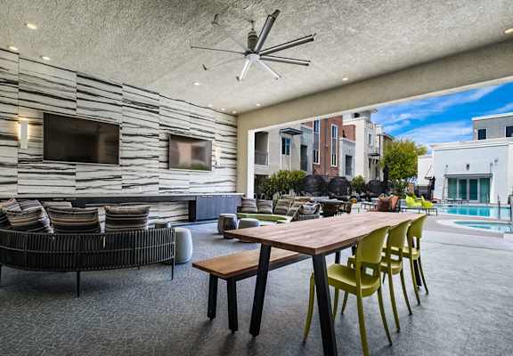 a clubhouse with a large table and chairs and a pool