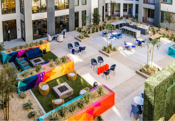 an aerial view of the courtyard of an office building with colorful tables and chairs