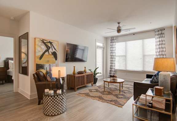A living room with a brown couch, a coffee table, and a painting on the wall.