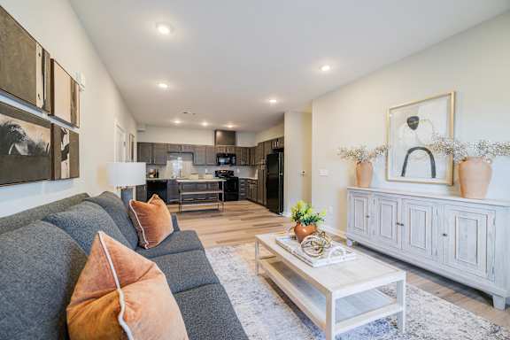 A modern living room with a grey couch and a coffee table.