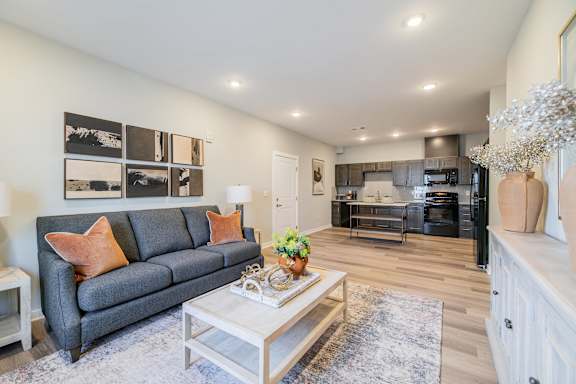 A modern living room with a grey couch and a coffee table.