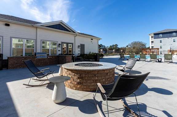 our patio has a fire pit and seating area with chairs and tables at Capstone at Banks Crossing, Commerce