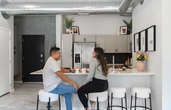 A man and a woman are sitting at a kitchen island.at Level, Des Moines, IA