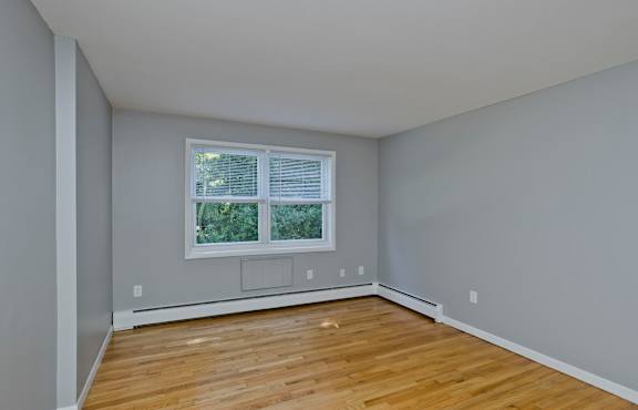 an empty room with wooden floors and a window at Hawkins Meadow in Amherst, MA, 01002