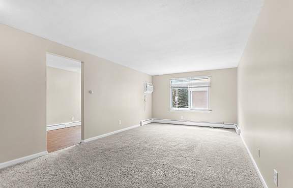 an empty living room with a window and carpet at Rose Hill Estates, Norwich, CT