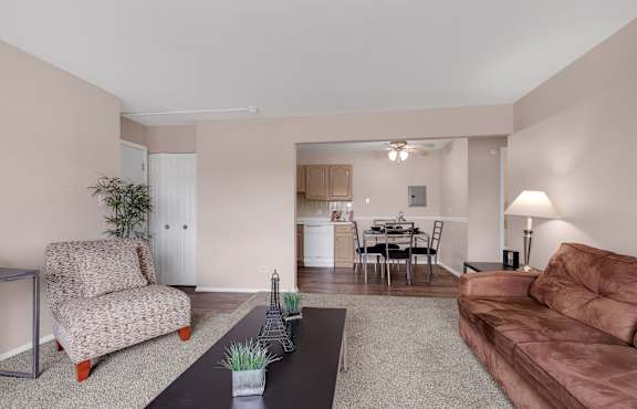 a living room with a leather couch and a coffee table at St Charles Square Apartments, Carol Stream, IL, 60188