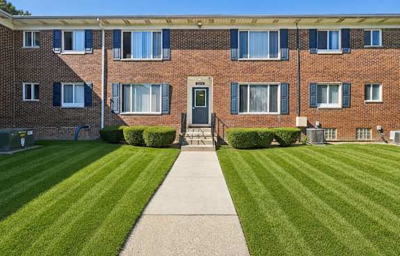 brick building with a green lawn in front.