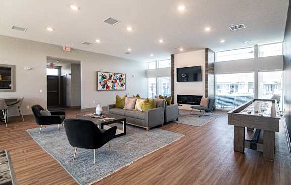 A modern living room with a pool table and a TV. at Centennial Crossing, Waukee, 50263