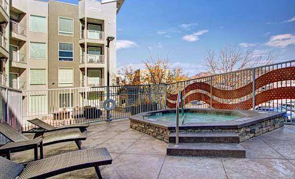 A modern building with a pool and a metal fence.