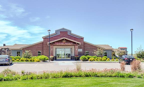 The exterior sign and building of Dakota Ridge Apartments. 