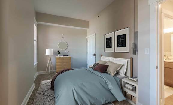A bedroom with a bed, nightstand, and lamp.