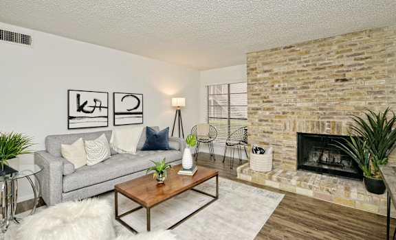 Living room with brick fireplace at Peaks @ NW Hills Apartments, Austin, TX 78731
