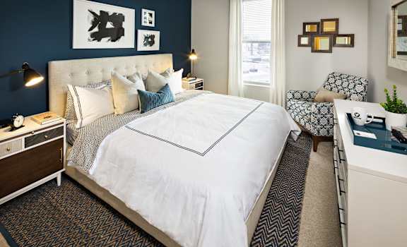 a bedroom with a large white bed and a blue accent wall