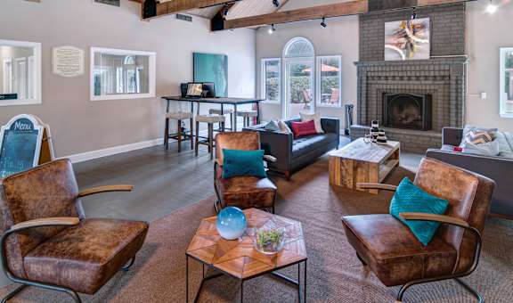 A living room with a fireplace and leather chairs.