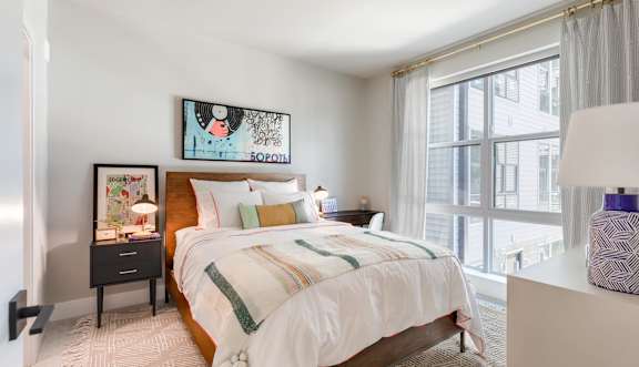A bedroom with a large bed and a painting above it. at Coda at Bryant Street, Washington, DC 20002