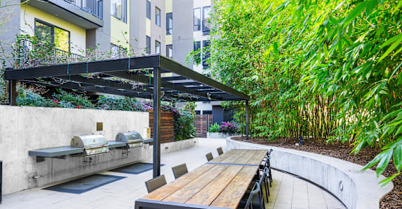 A patio with a table and chairs under a roof.