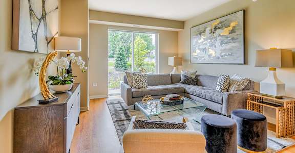 a living room with a couch and a glass coffee table at Avant at the Arboretum, Lisle, 60532