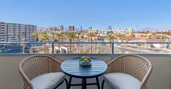 a balcony with two chairs and a table overlooking the city at The Rays at Vegas Towers Apartments, Nevada