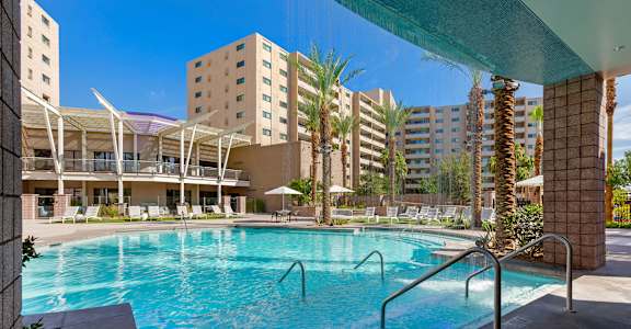 a swimming pool with a building in the background at The Rays at Vegas Towers Apartments, Las Vegas