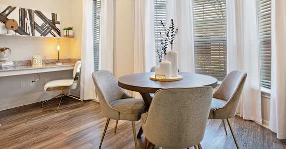 a dining room with a table and chairs and windows at Volare at the Woodlands, The Woodlands, TX