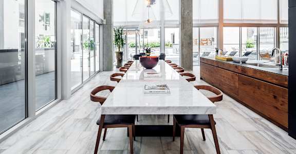 A modern dining room with a marble table and wooden chairs. at G12 Apartments, Los Angeles, CA, 90015