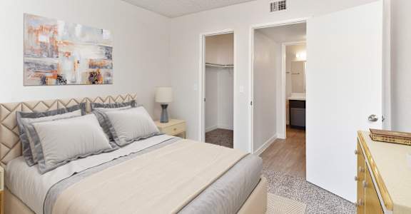 A bedroom with a large bed and a painting on the wall.