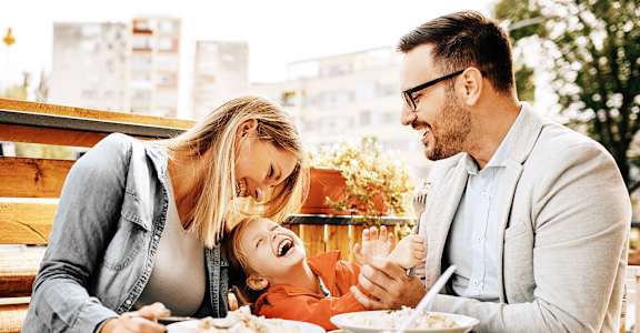 a man and woman sitting at a table with a child