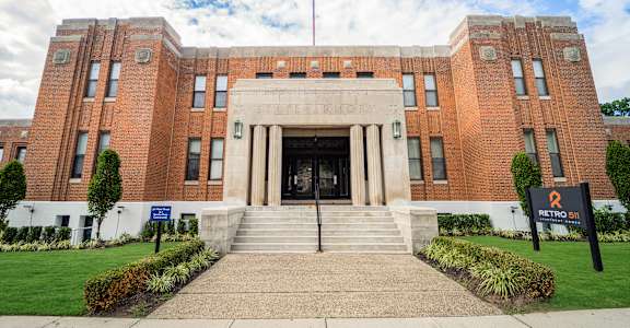 a large brick building with stairs in front of it at Retro 511 Apartments, West Haven, CT 06516