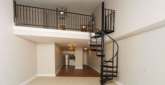 the loft in the great room of a house with a spiral staircase at Retro 511 Apartments, West Haven, CT