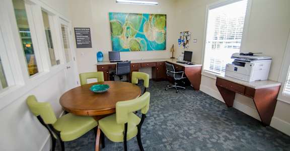 A conference room with a table, chairs, and a printer.