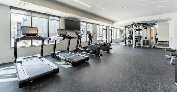 A gym with treadmills, elliptical machines, and other exercise equipment.