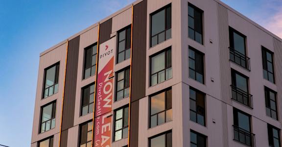 A building with a sign that says "Now Lease" on the side.